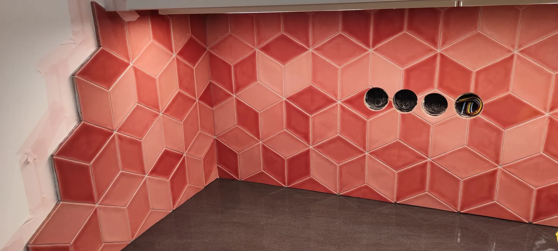 Konyhai hátfal piros, háromdimenziós hatású hexagon csempével, sarokillesztéssel