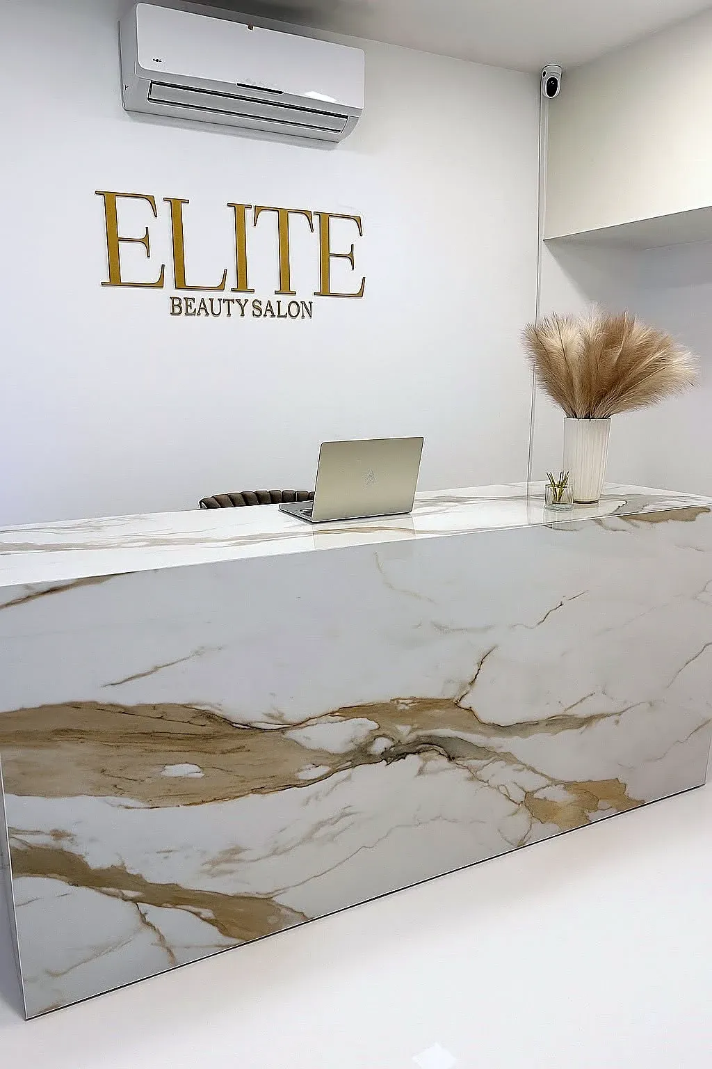 Az Elite Beauty szalon recepciós pultja, calacatta márványmintás óriáslapokkal burkolva